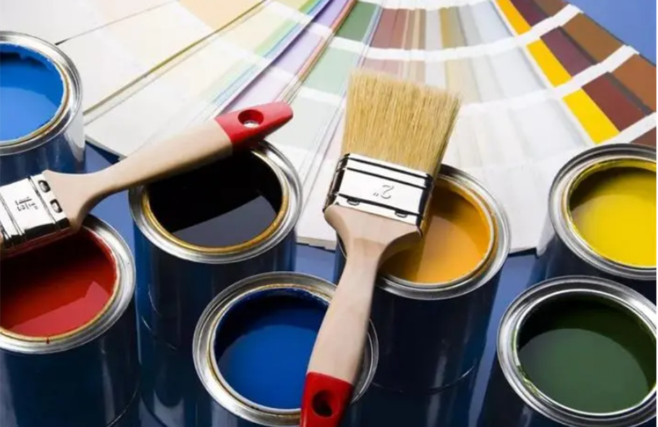 A plant in a field covered with black foil, persons working in the background.